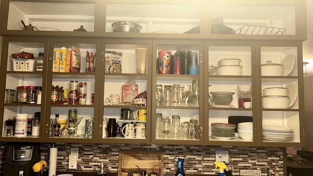 Open kitchen shelving unit before refinishing, in a brown wood finish
