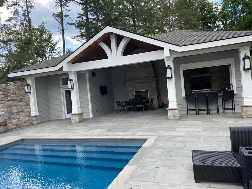 Backyard pool cabana with crisp white board-and-batten siding and dark trim, freshly painted by Prime Choice Painters